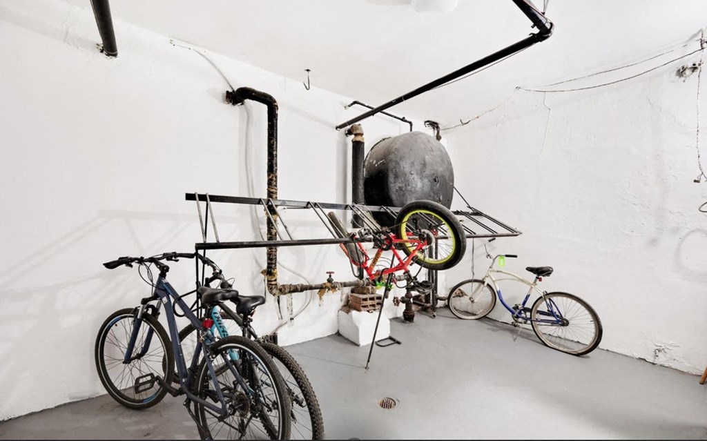 A bicycle repair shop with a variety of bikes and a large air pump.