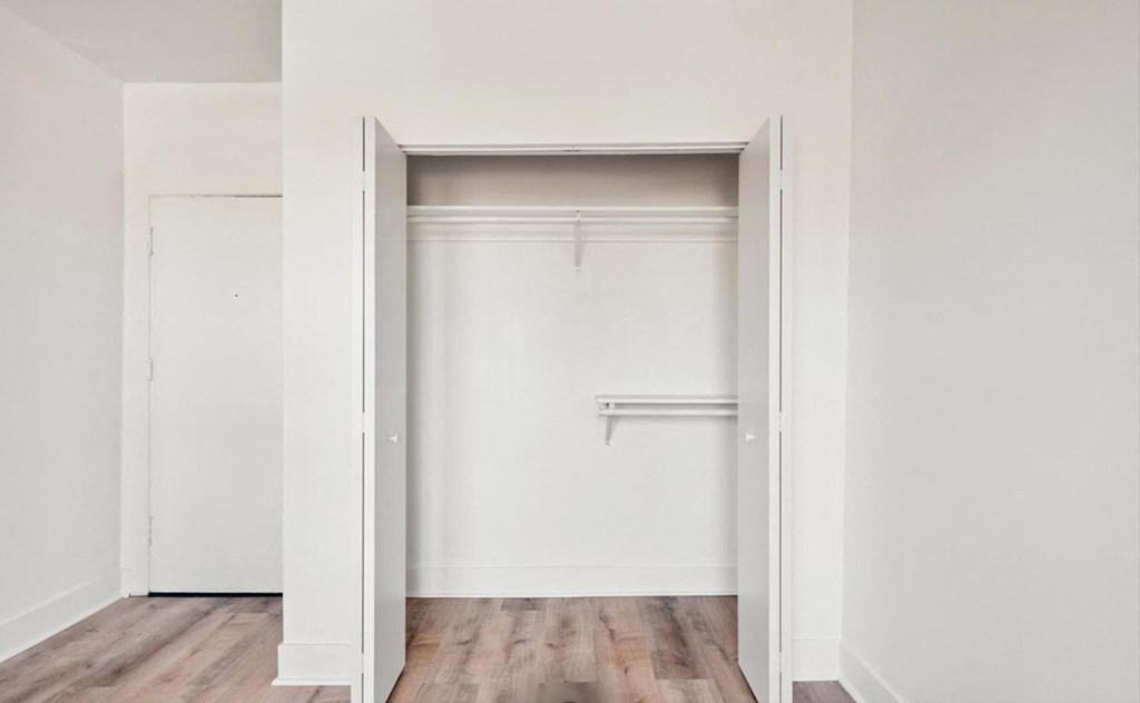A white doorway leads to a room with a wooden floor.