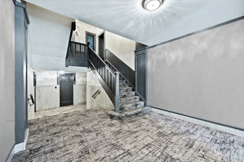 the entryway of a house with a staircase and a ceiling light