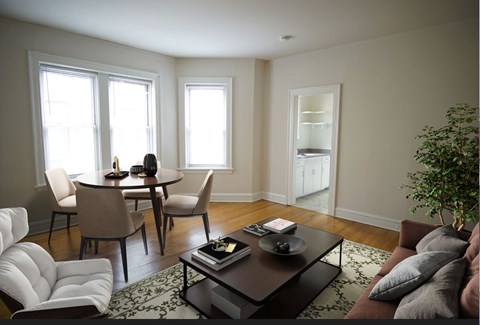 A living room with a brown couch, a coffee table, and a dining table with chairs.