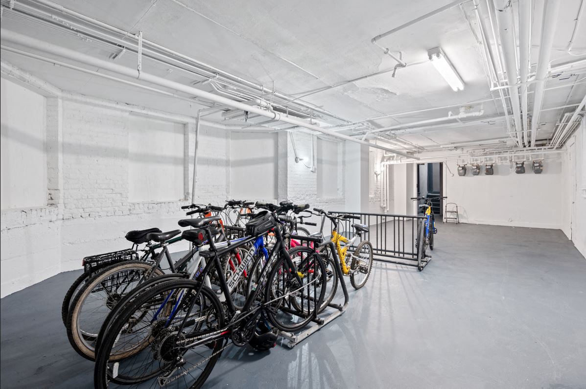 A bike rack with many bikes in a white room.