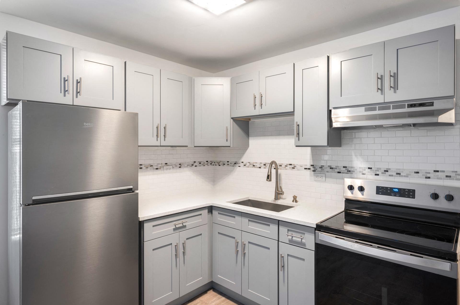a kitchen with white cabinets and stainless steel appliances