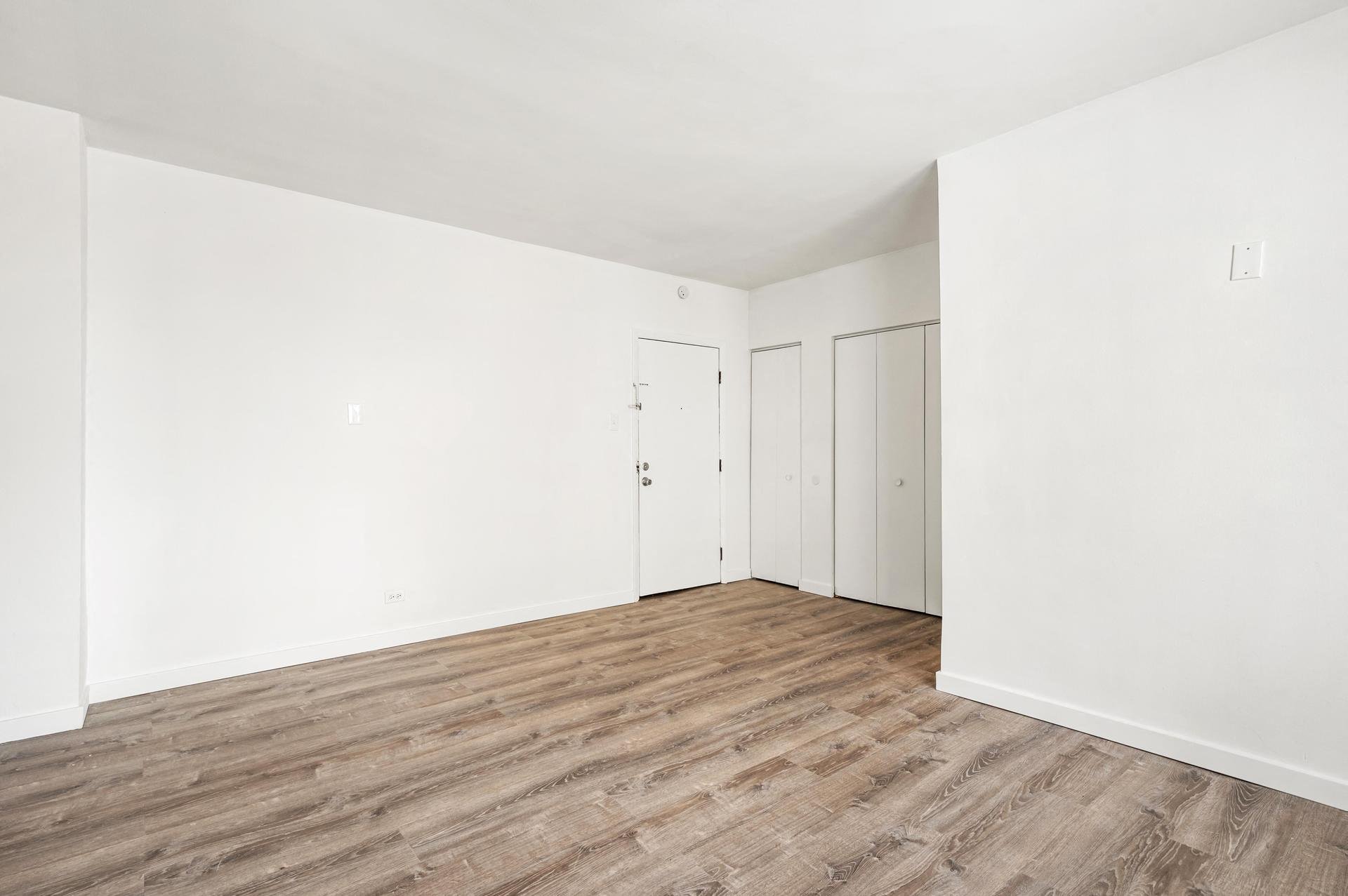 a living room with white walls and wood floors