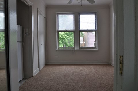 an empty room with two windows and a door