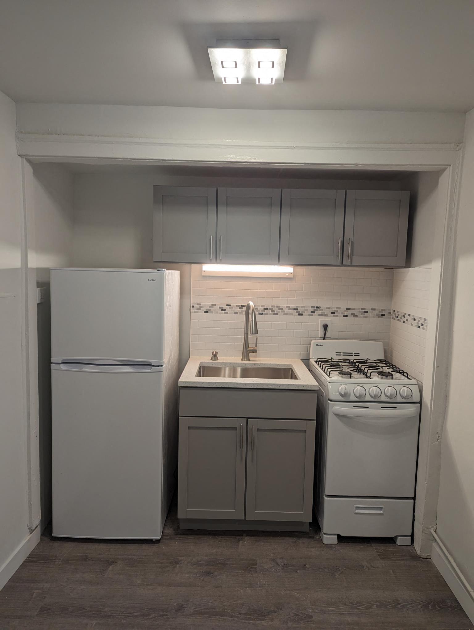 a kitchen with a stove refrigerator and a sink
