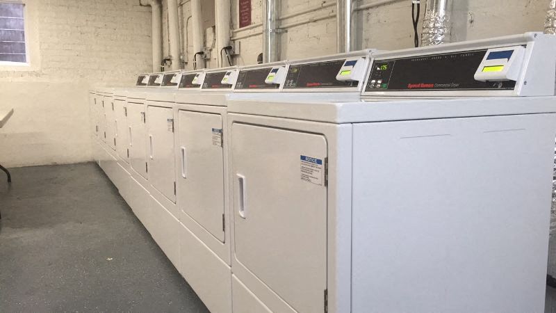 a row of white washing machines in a building
