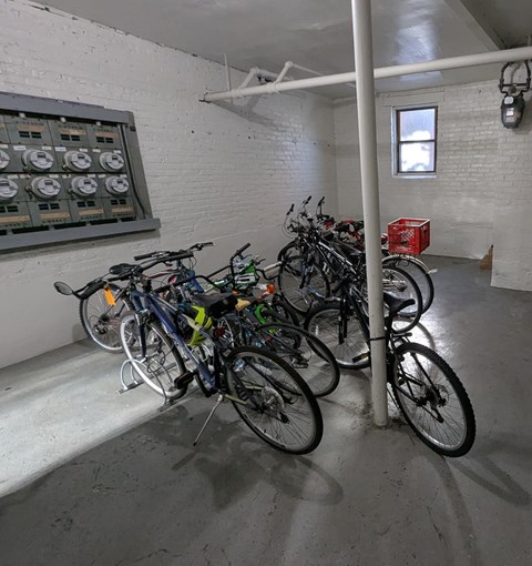 A room with a white brick wall and a row of bicycles.