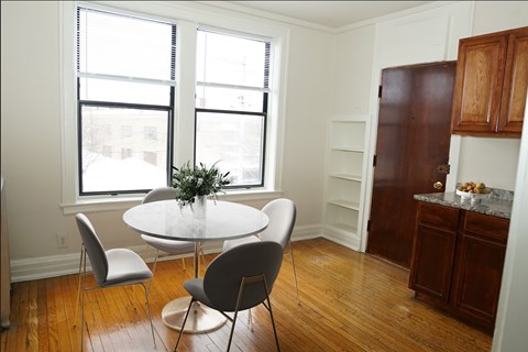 A dining room with a white table and chairs.