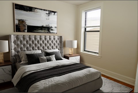 A bedroom with a large bed and a painting on the wall.