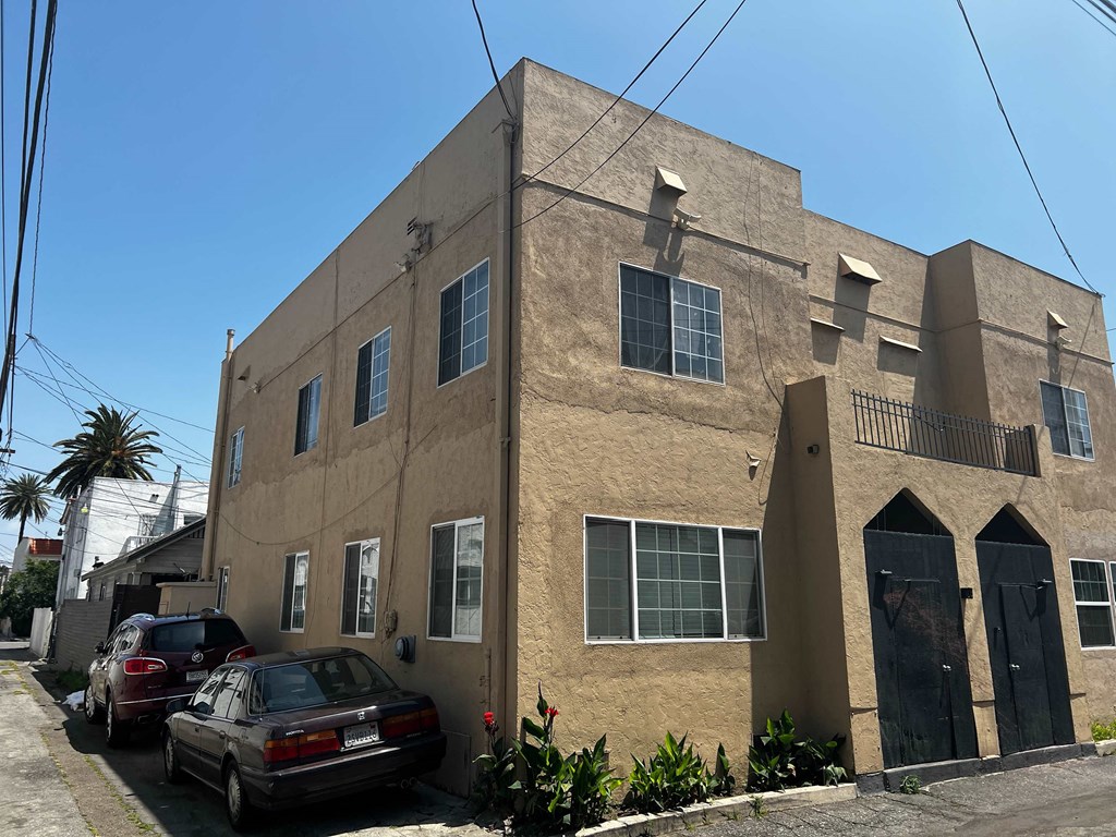 the exterior of a building with cars parked outside of it