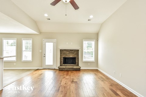 A spacious room with a fireplace and a ceiling fan.