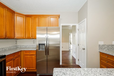 A kitchen with wooden cabinets and a stainless steel refrigerator.