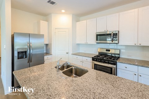a kitchen with granite counter tops and stainless steel appliances