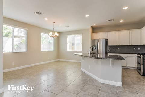 A spacious kitchen with a large island and a dining area.