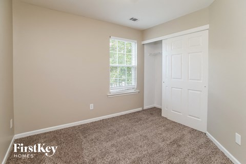 a bedroom with carpet and a white door