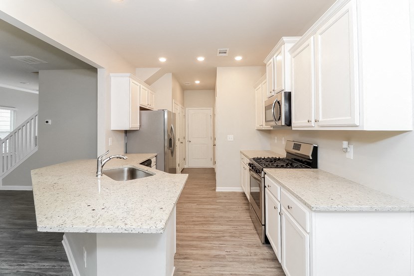 a kitchen with white cabinets and white counter tops and a sink