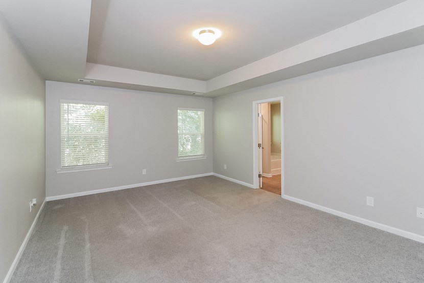 an empty living room with white walls and carpet
