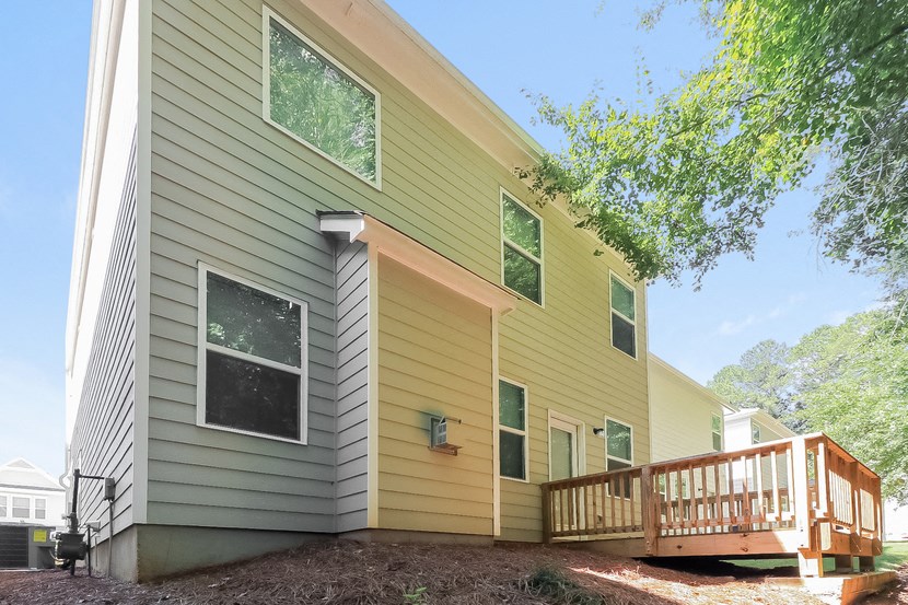 the back of a house with a deck and a tree