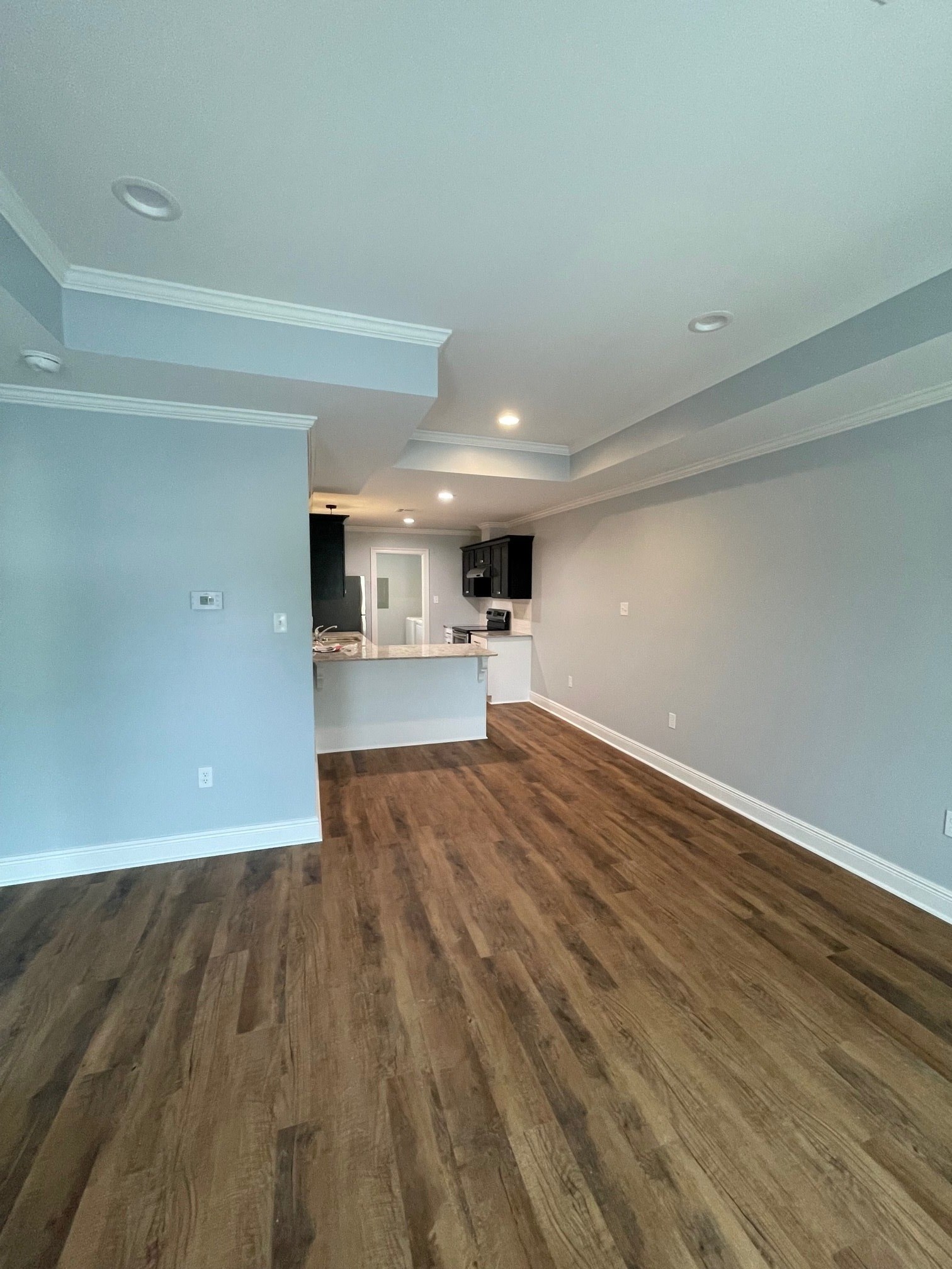 the living room and kitchen of a new home with wood flooring