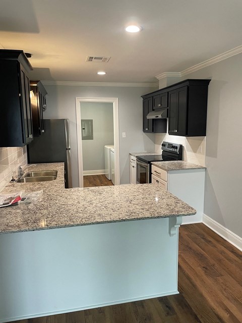a kitchen with granite counter tops and black cabinets