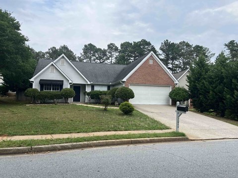 a house with a yard and a parking meter in front of it