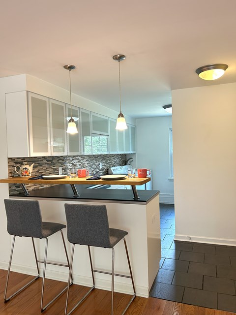 A kitchen with a bar area and two chairs.