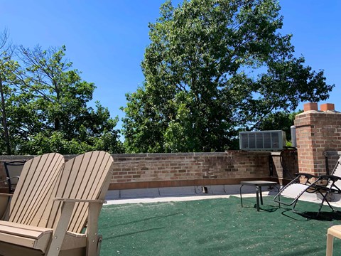 Two chairs are on a green lawn.