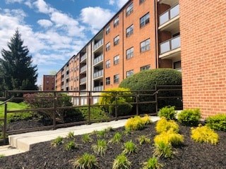 A red brick building with a garden in front.