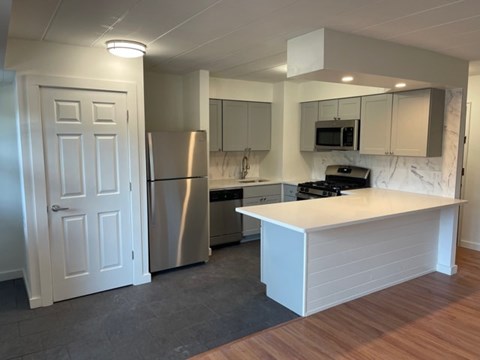 A kitchen with a white island and stainless steel appliances.