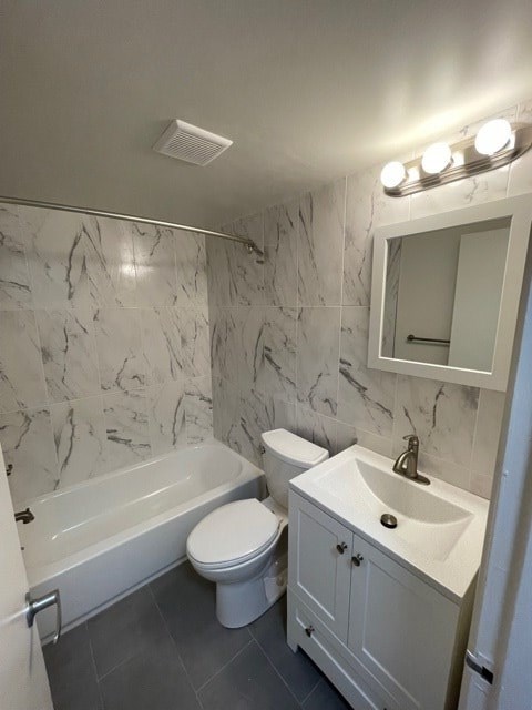 A white bathroom with a marble wall and a white toilet.
