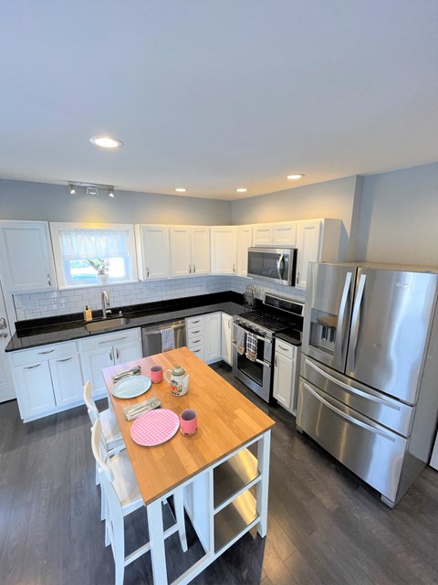 a kitchen with stainless steel appliances and a wooden table