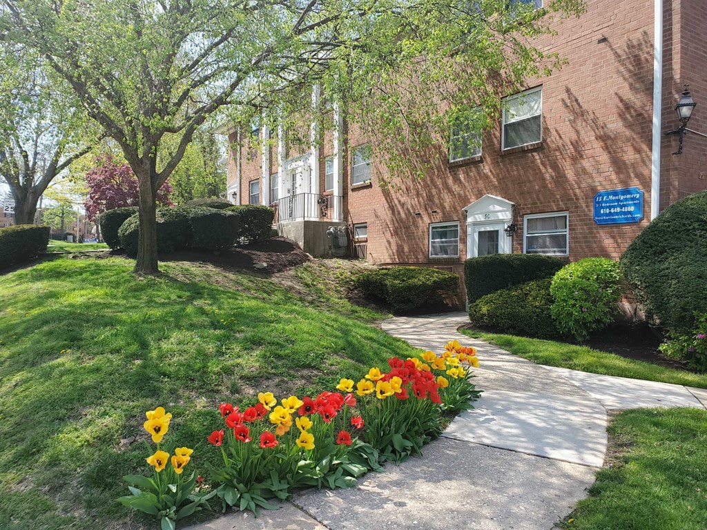 a flower garden in front of a brick building