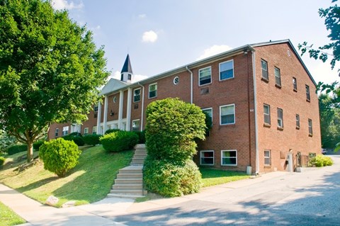 A red brick building with a steeple on the roof.