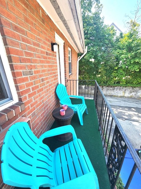 Two blue chairs on a balcony.