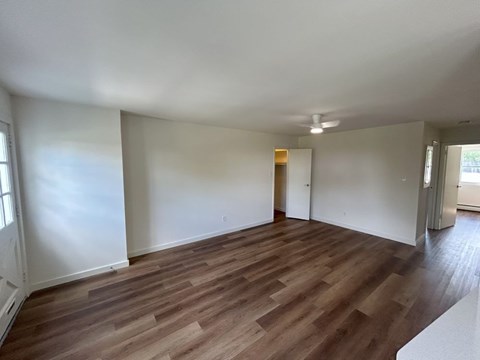 A room with wooden flooring and white walls.