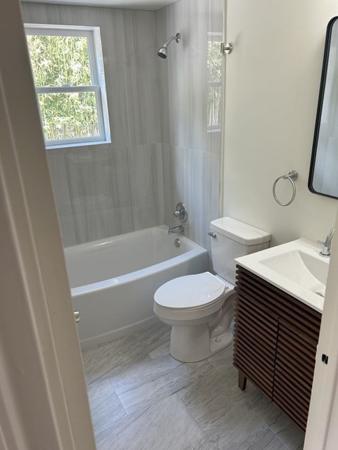 A white toilet sits next to a white sink in a bathroom.