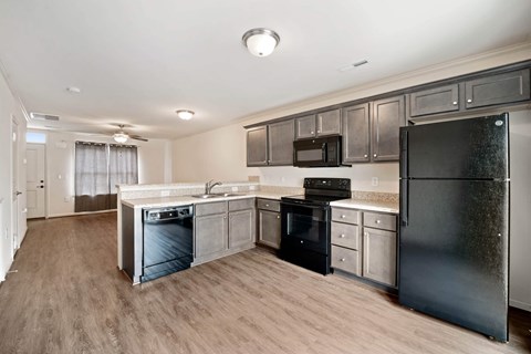 a kitchen with stainless steel appliances and wooden floors