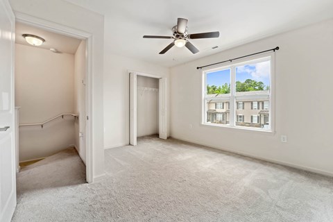 an empty room with a ceiling fan and a window