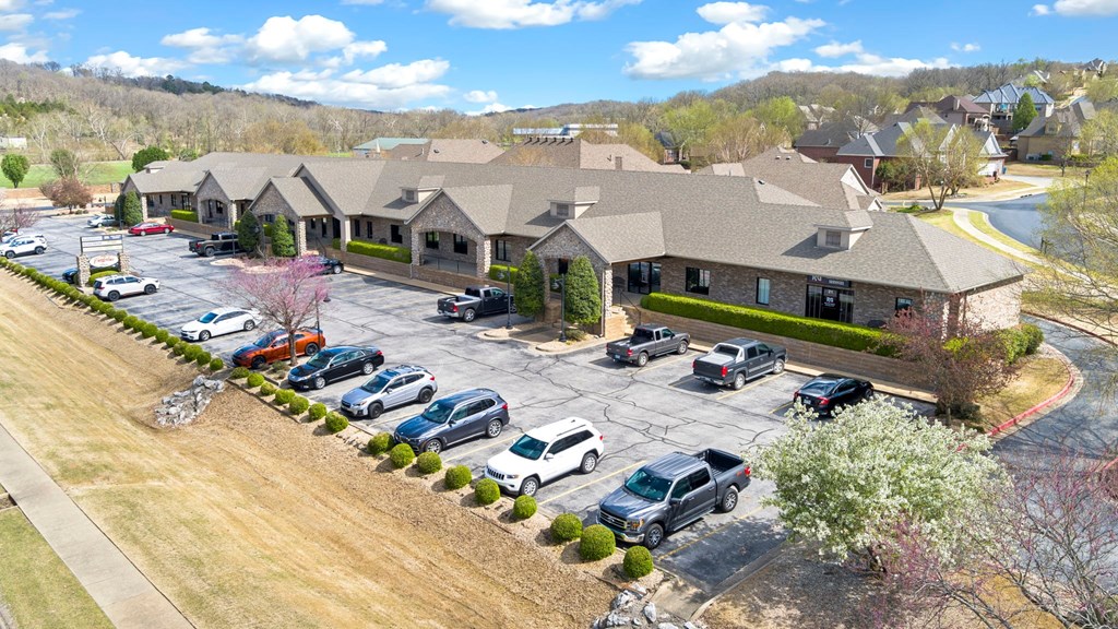 A parking lot in front of a building with cars parked.