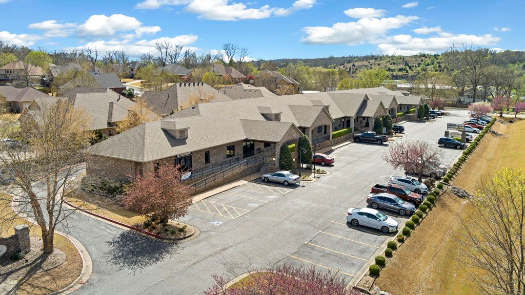 A parking lot in front of a building with cars parked.