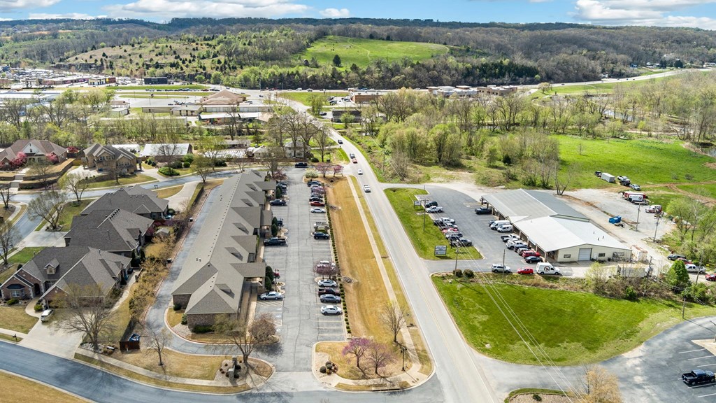 A suburban area with houses, a parking lot, and a road.