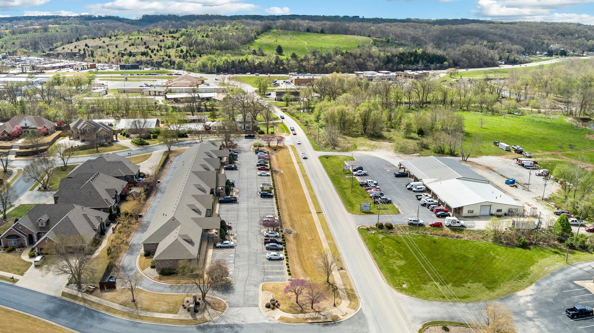 A suburban area with houses, a parking lot, and a road.