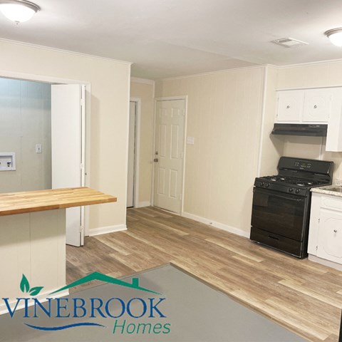 A kitchen area with a stove and cabinets.