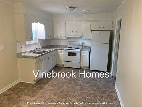 a kitchen with white cabinets and a white refrigerator