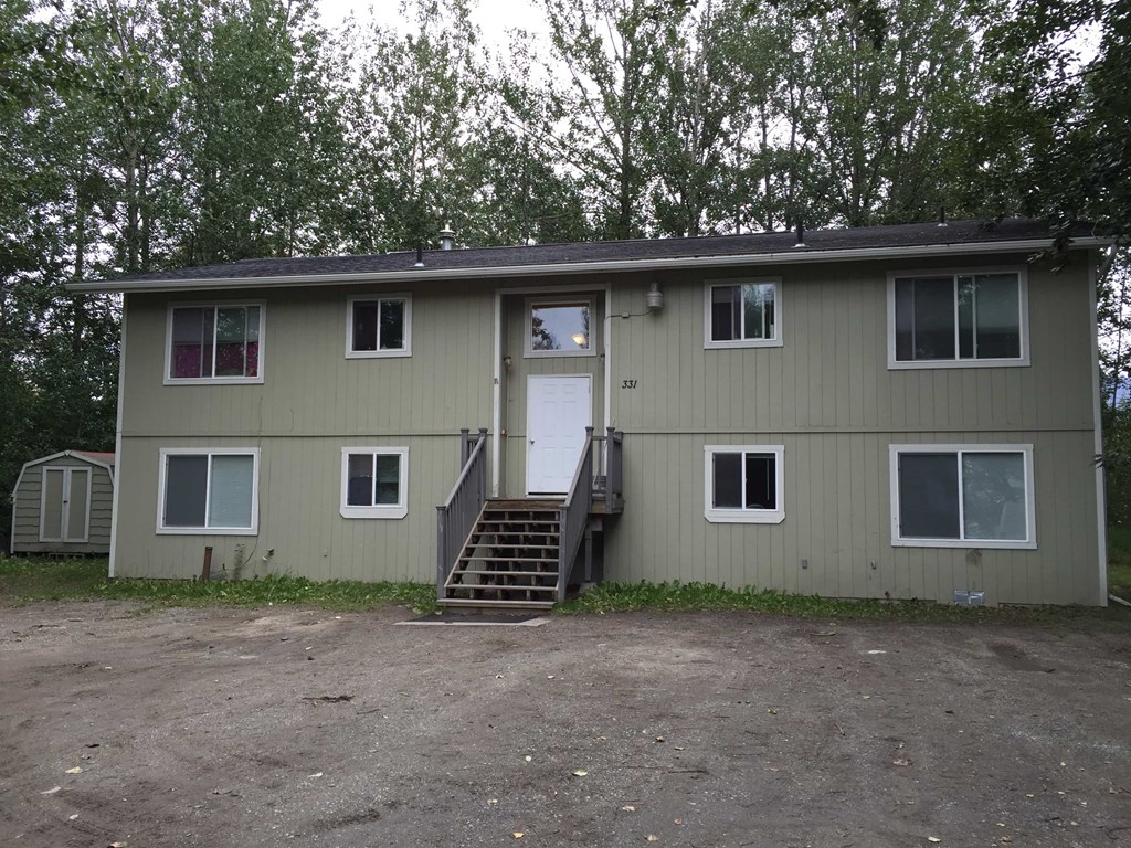 the front of a house with stairs and a door