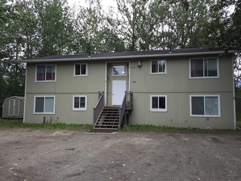 the front of a house with stairs and a door