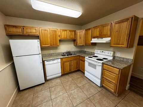 A kitchen with white appliances and wooden cabinets.