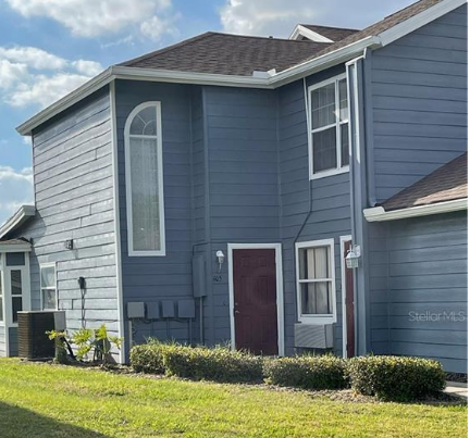 a blue house with a yard in front of it