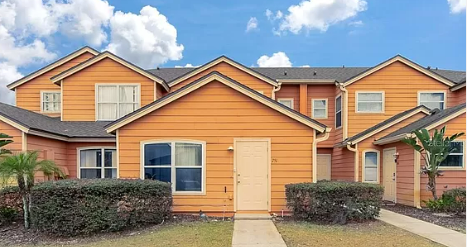 an orange house with a sidewalk in front of it