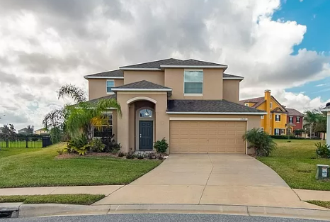 a beige house with a driveway and a garage door